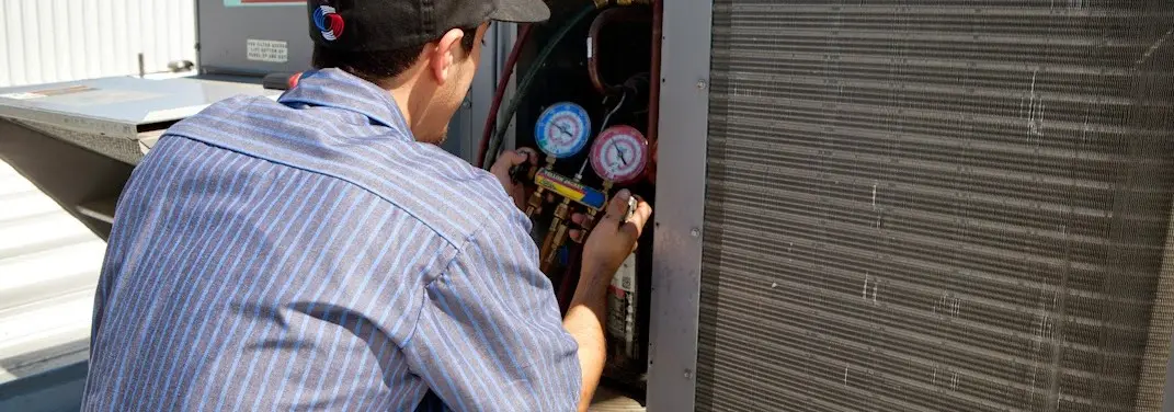 HVAC technician servicing a condenser unit in Solon